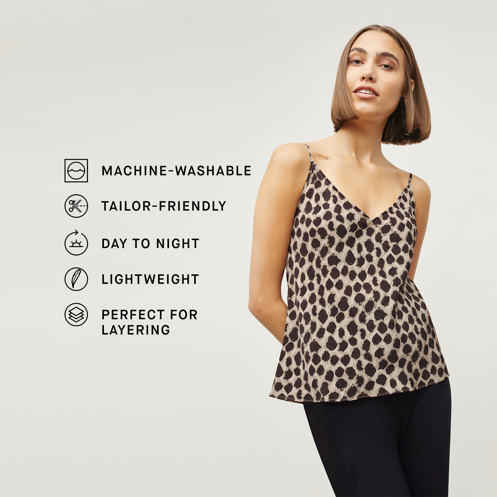 Front image of a woman standing wearing the Lisey Cami—Sahara Print Washable Silk in Tan/Black with the product features listed