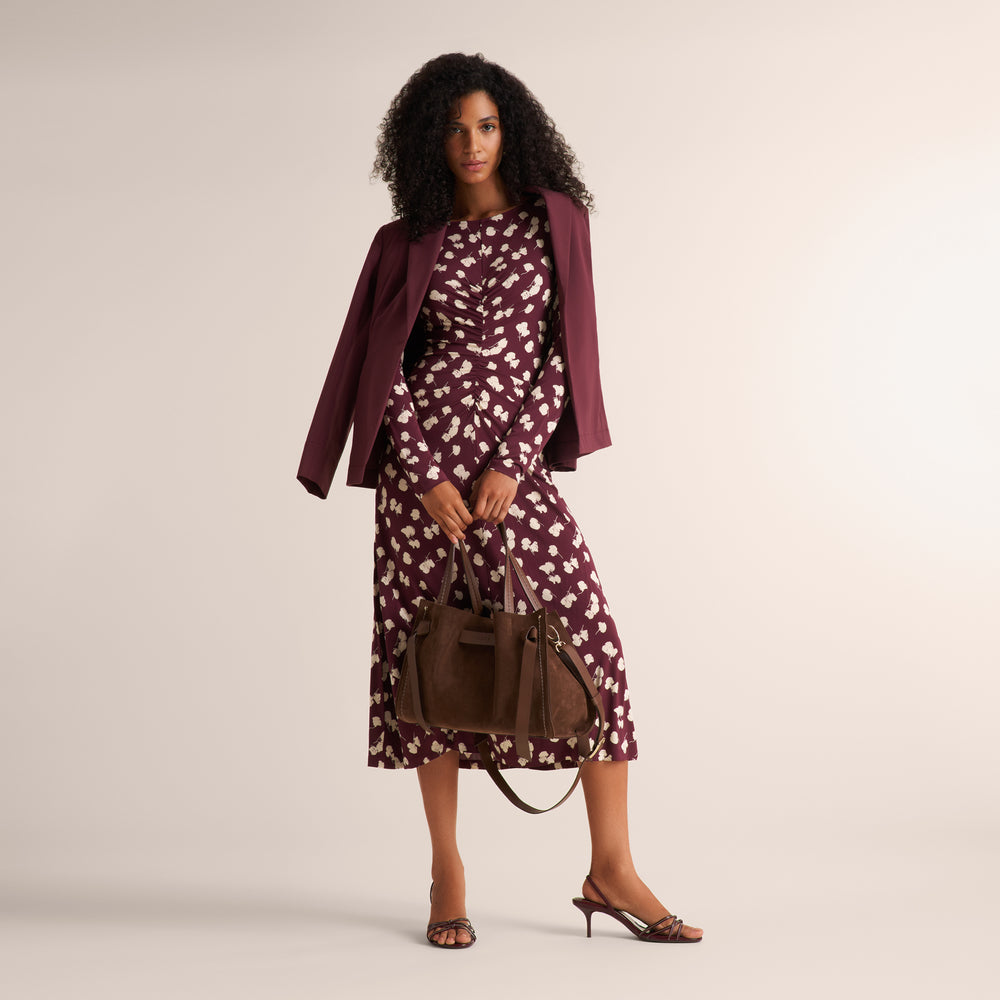 image of a woman holding a brown suede visona handbag