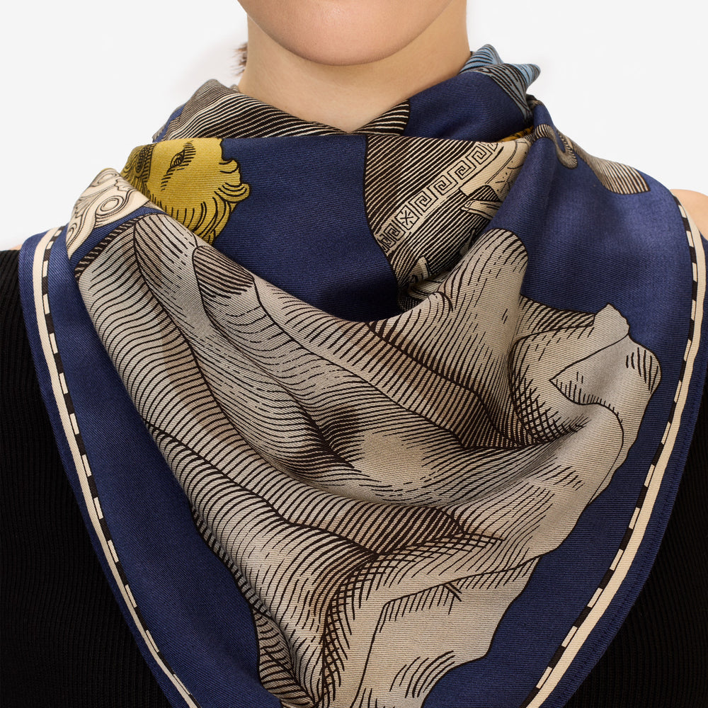 Navy blue and beige patterned scarf draped around a person's neck.