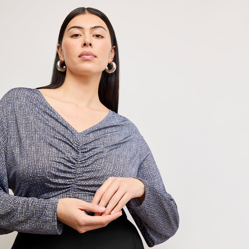 Front image of a woman wearing the amina top in blueprint sketch