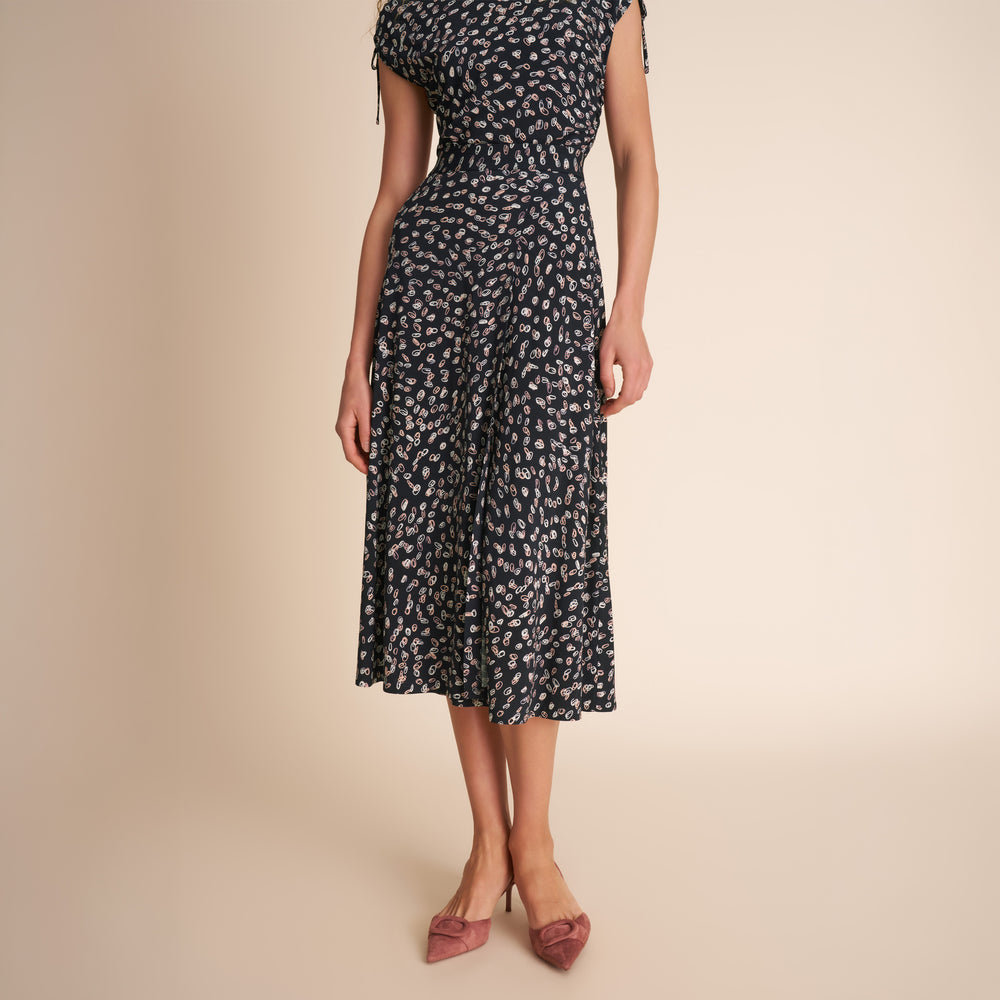 Woman wearing a black and white patterned dress on a beige background