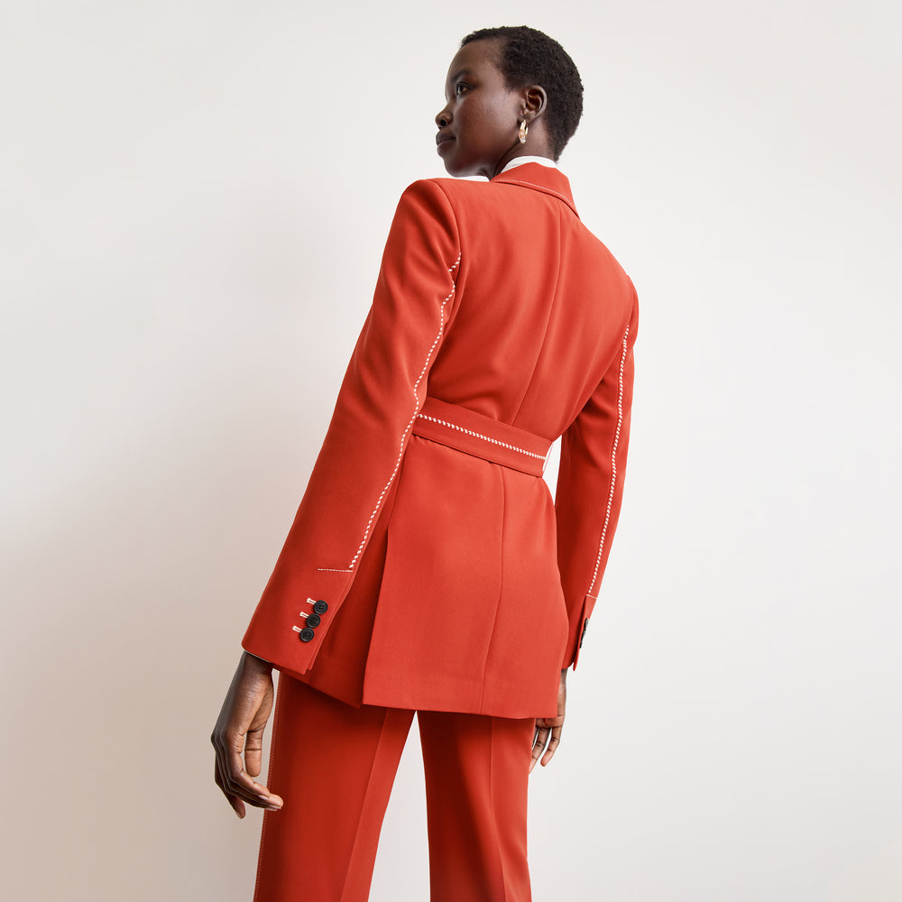 back image of a woman wearing the athena blazer in ginger with topstitch