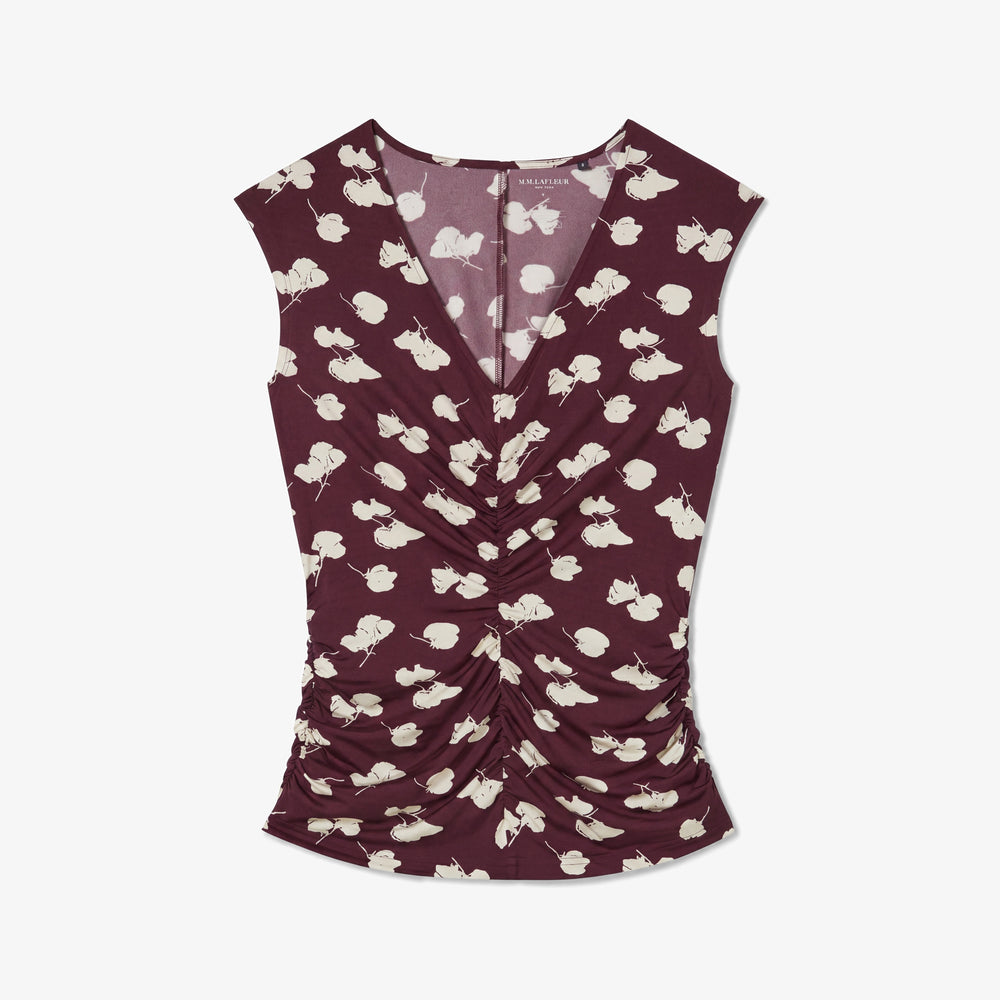 A sleeveless wrap-style top in deep burgundy with an allover cream floral print, shown flat against a light gray background.