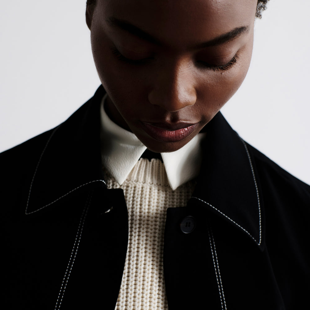 front image of a woman wearing the nicky jacket in black