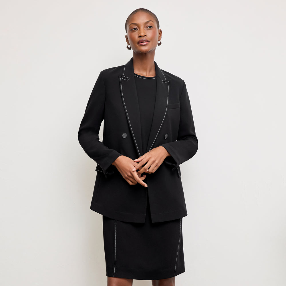 front image of a woman wearing the lancia dress in black with topstitch