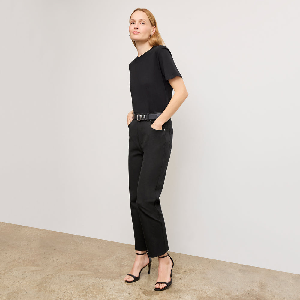 Front image of a woman standing wearing the leslie top in compact cotton in black