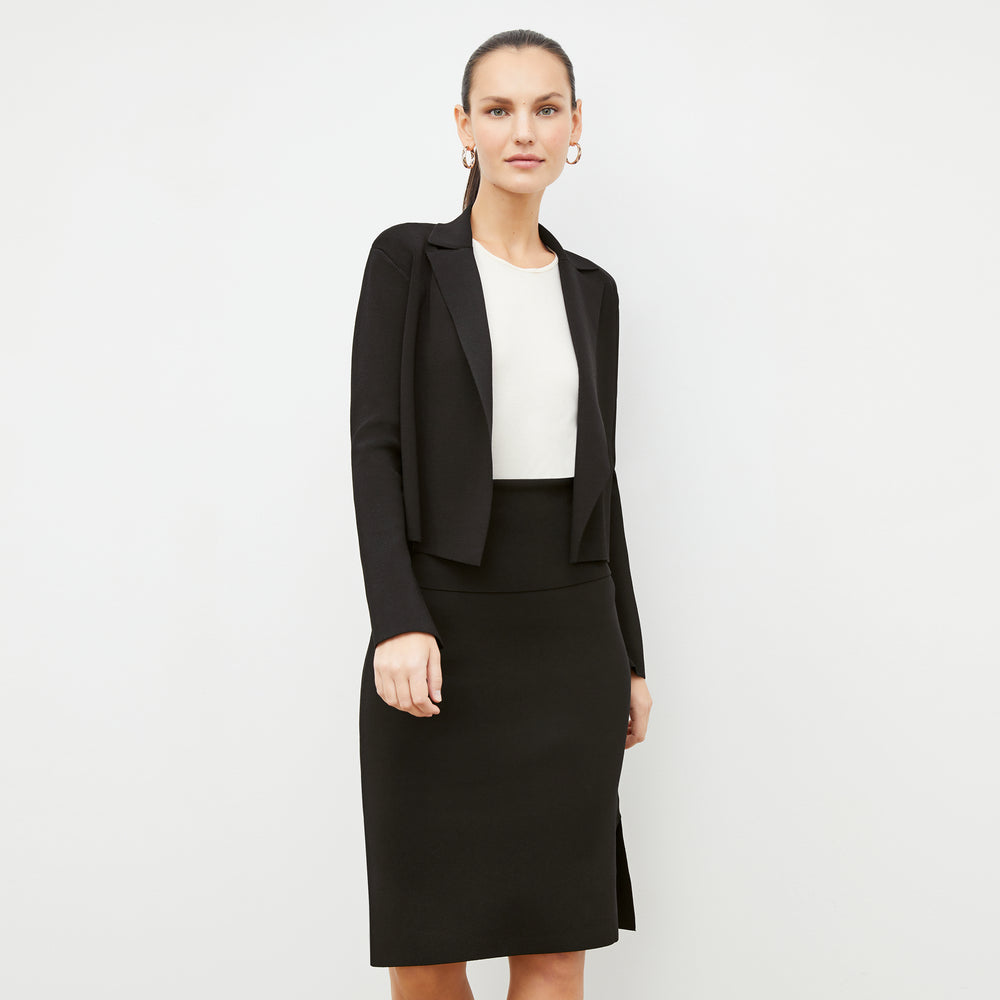 Front image of a woman standing wearing the harlem skirt in black