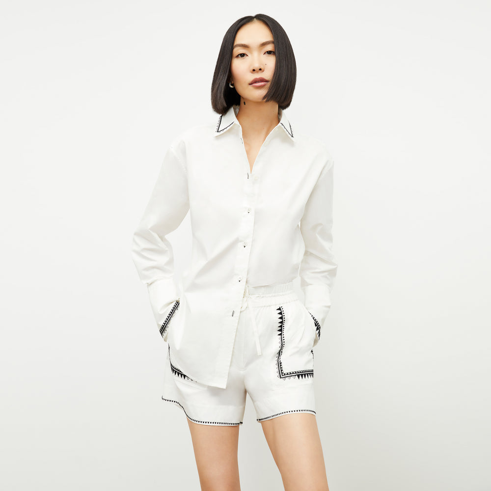 front image of a woman wearing the mila button down in white
