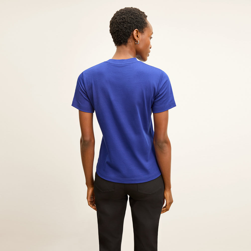 back image of a woman wearing the leslie t-shirt in bright indigo