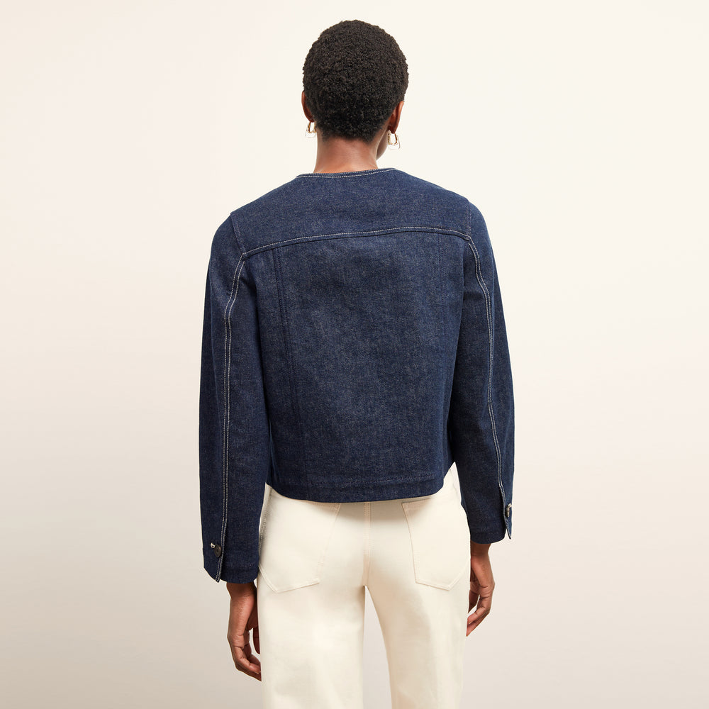back image of a woman wearing the kane jacket in dark wash