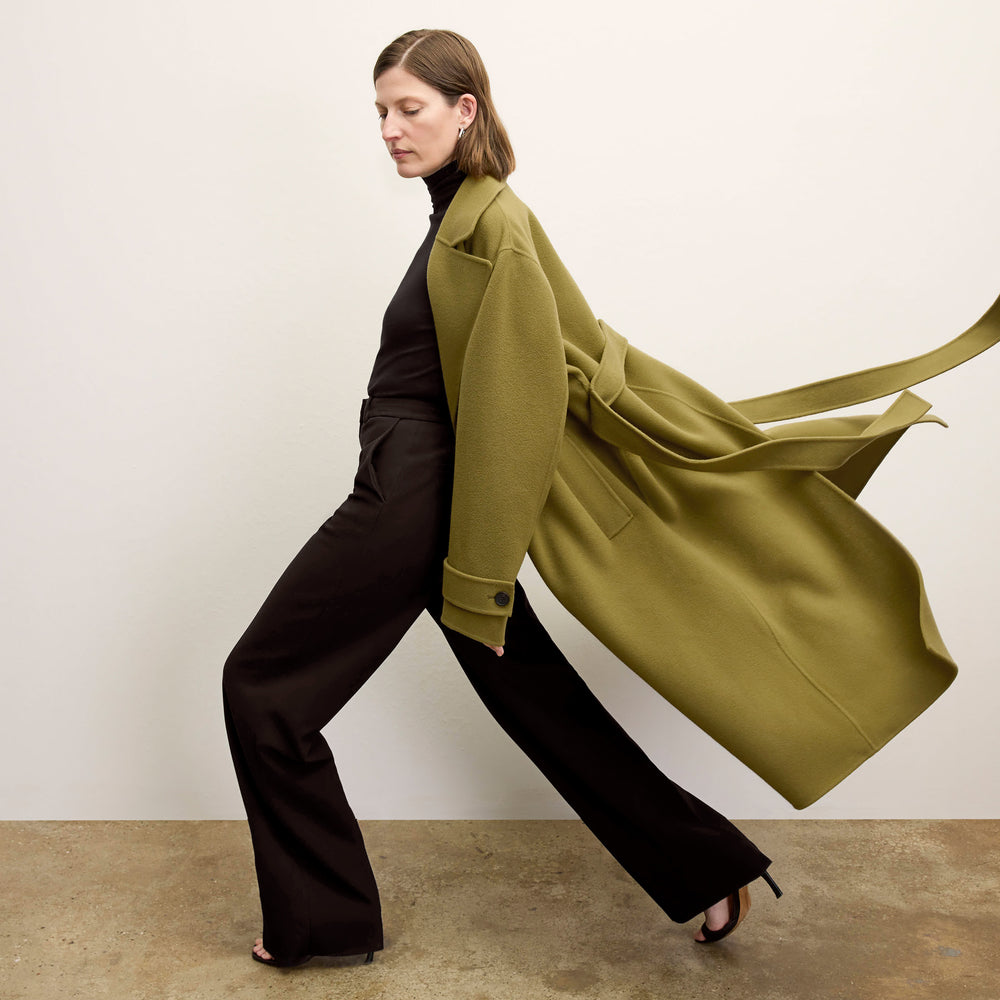 side image of a woman wearing the viola coat in pistachio
