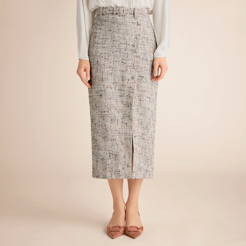 Person wearing a patterned skirt on a beige background
