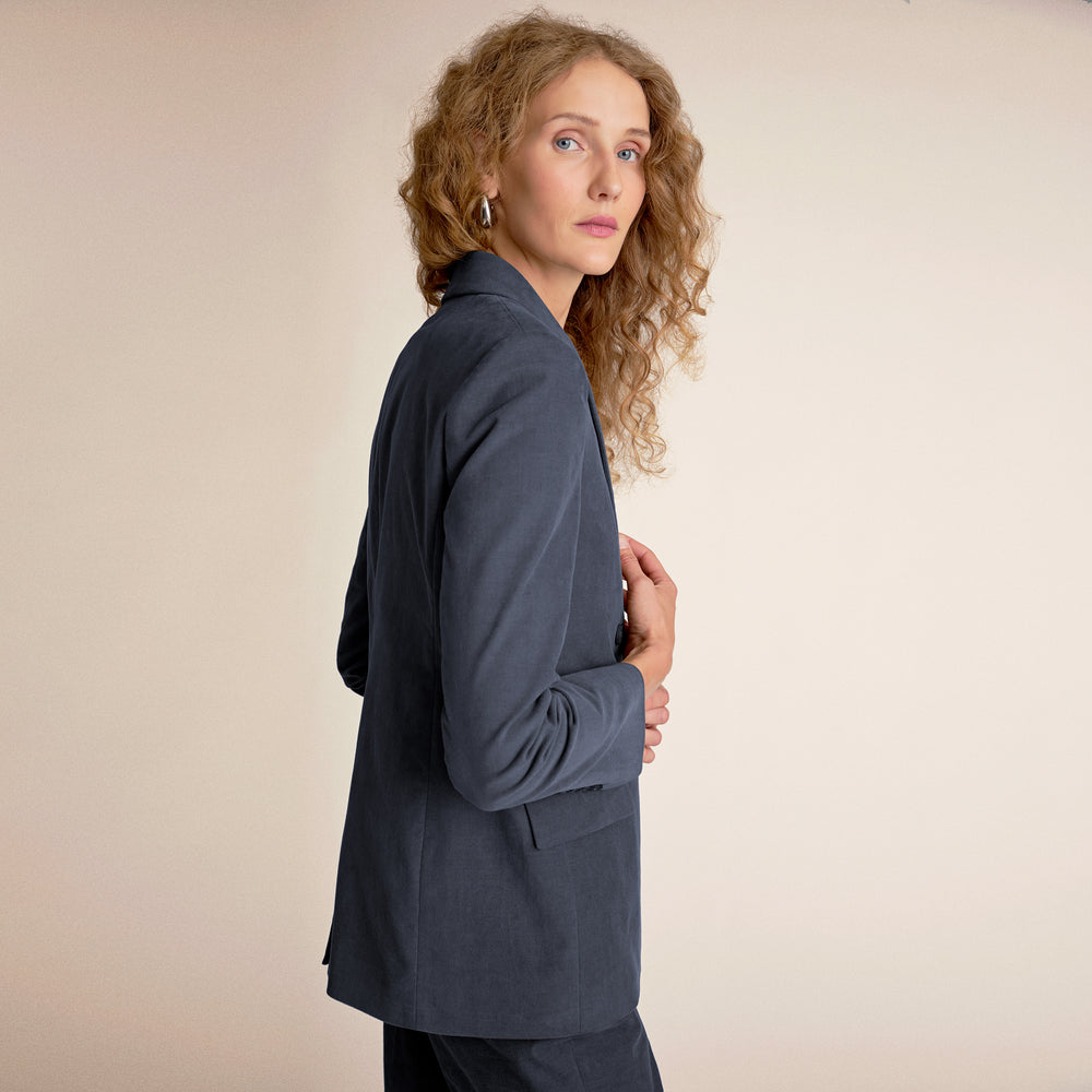 Woman wearing a gray suit on a beige background