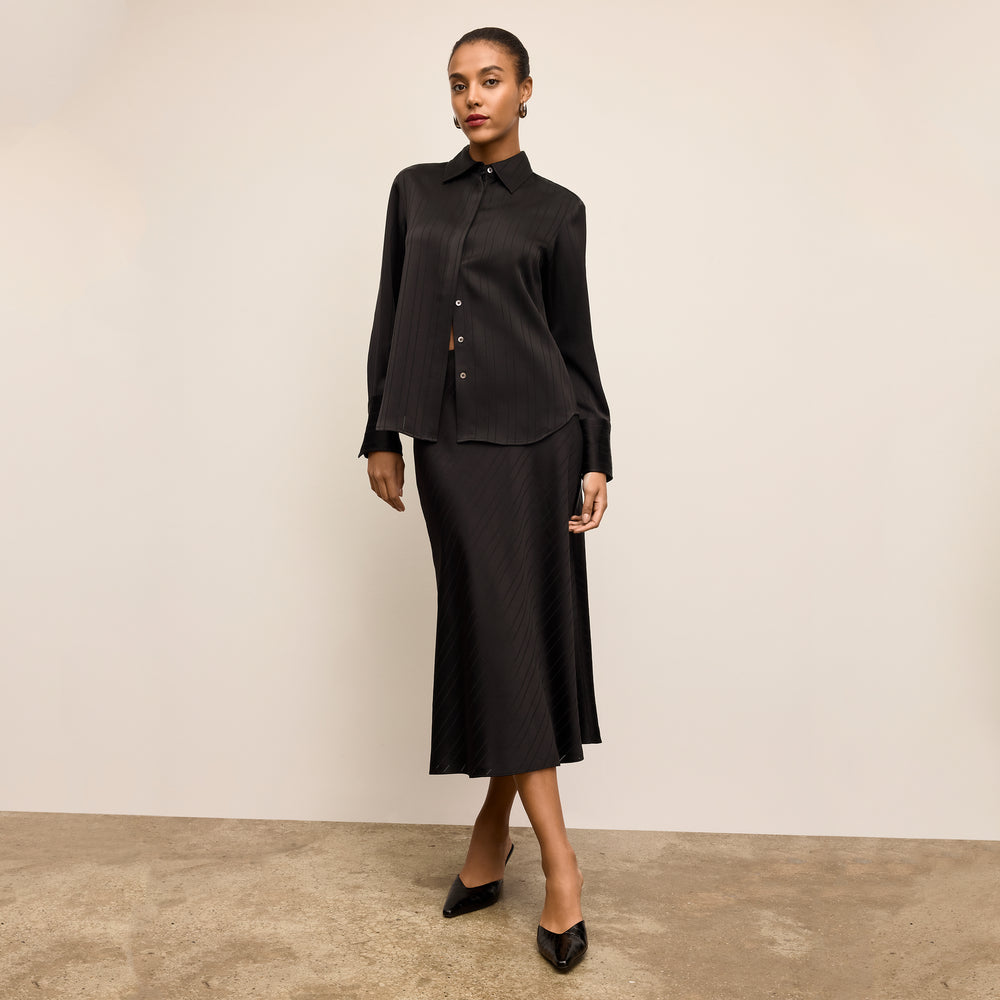 Woman wearing a black dress against a plain background
