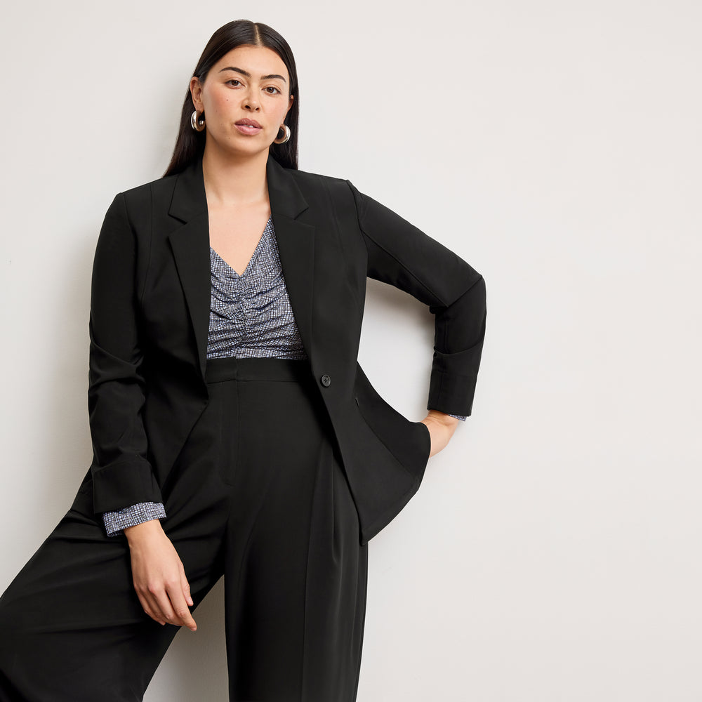 Woman wearing a black suit with a white background