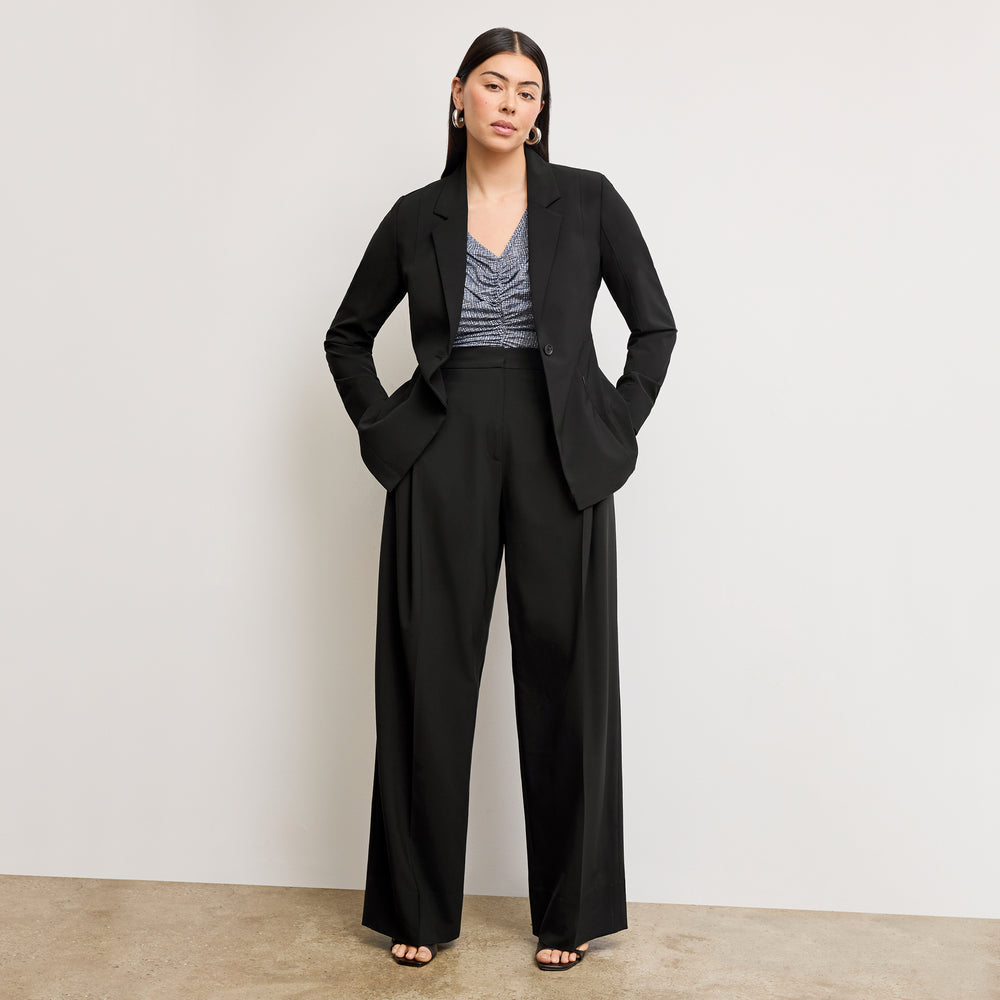 Woman wearing a black suit with a plain background