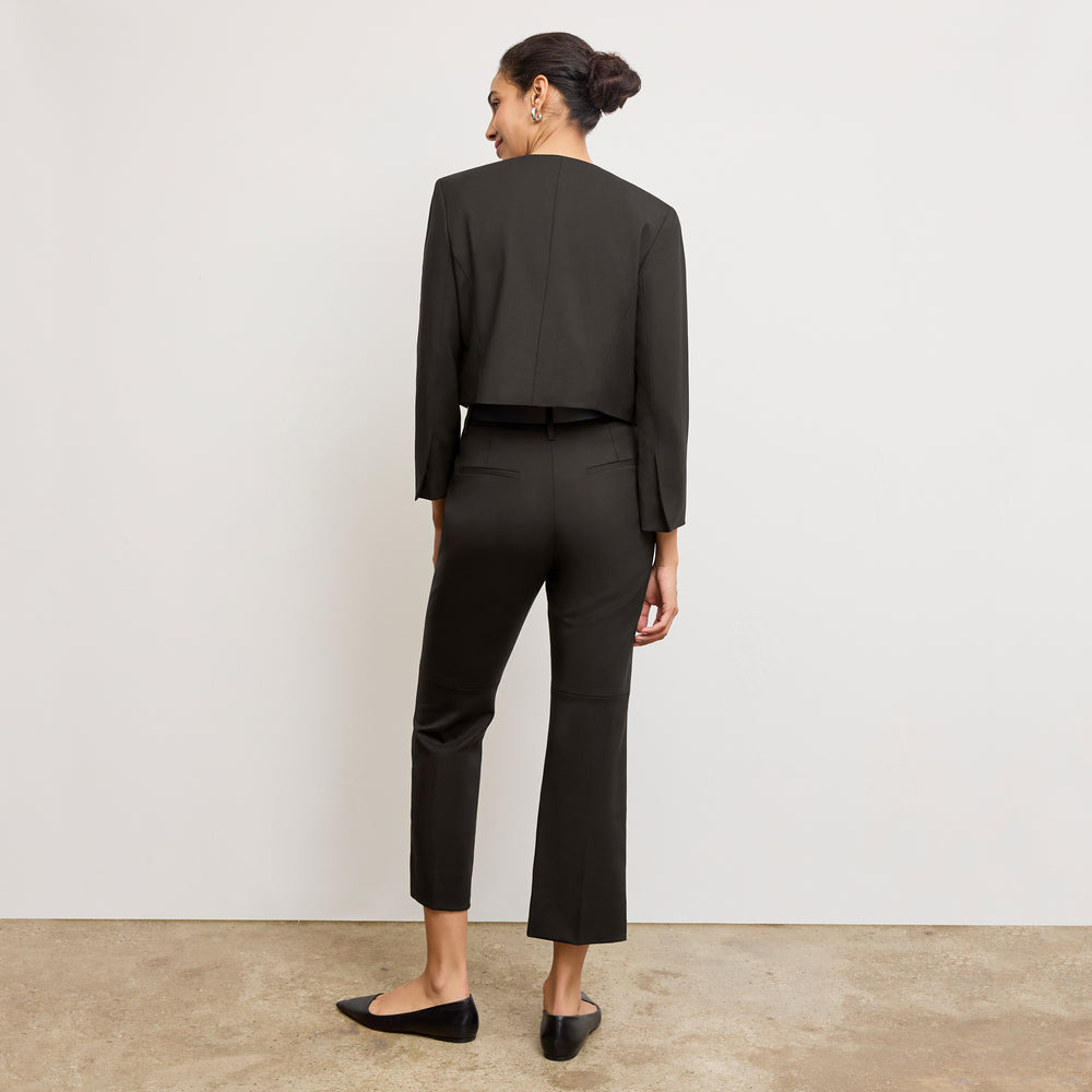 Front image of a woman standing wearing the Neale jacket in black