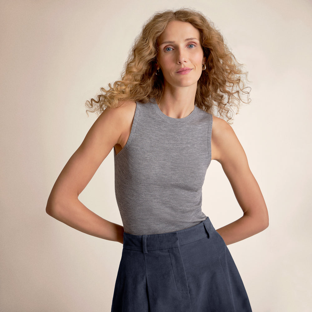 Woman wearing a gray tank top and a blue skirt