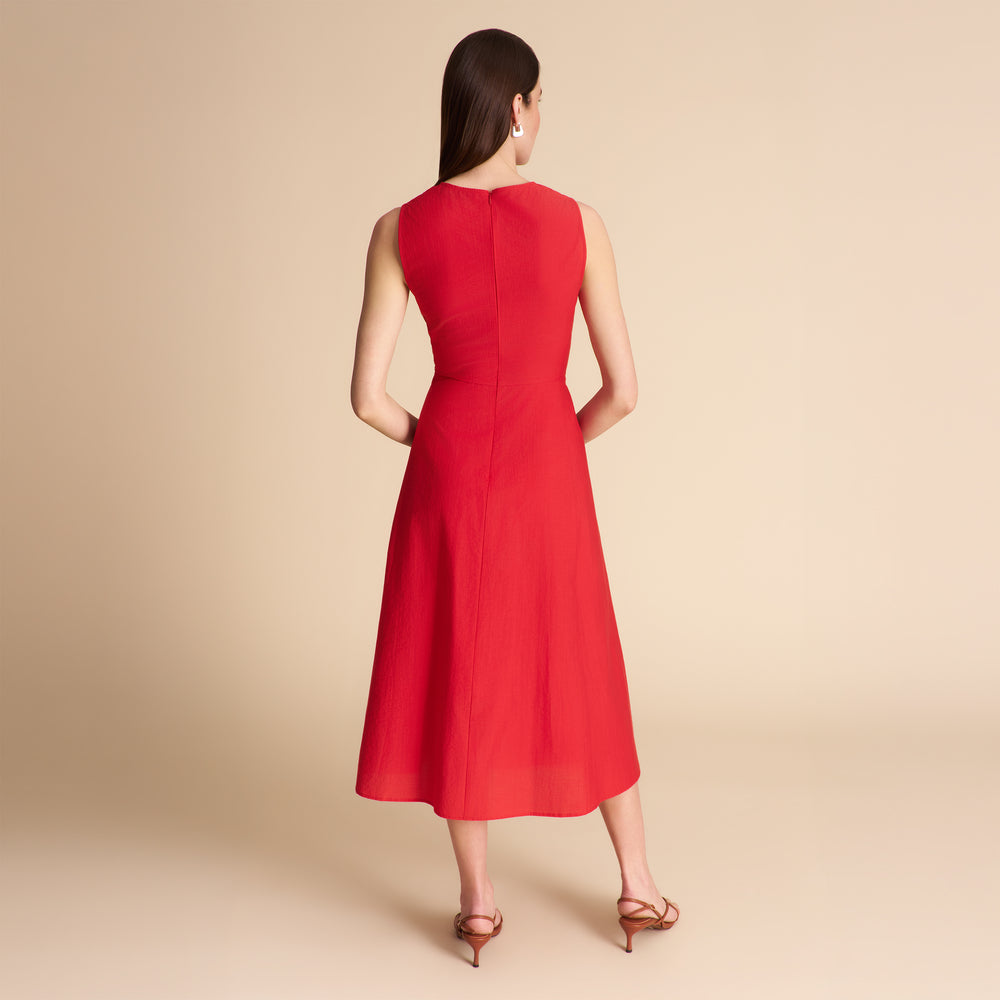 Woman wearing a red dress against a beige background