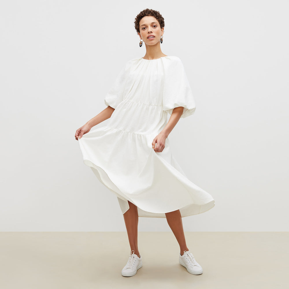 Front image of a woman standing wearing the medina dress in textured voile in ivory