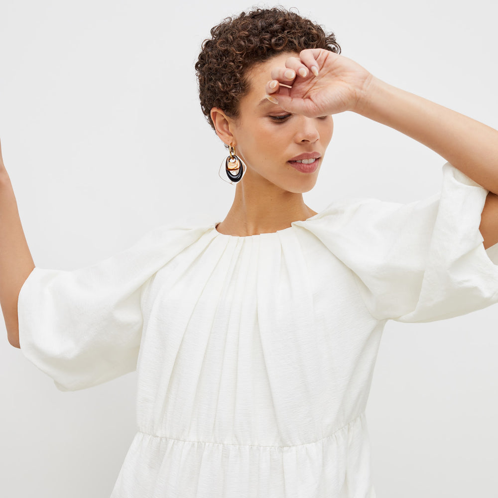 Detail image of a woman standing wearing the medina dress in textured voile in ivory