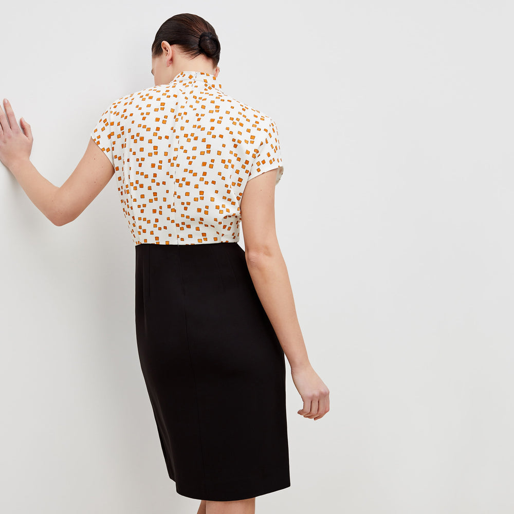 Back image of a woman standing wearing the adelaide dress in mosaic print in goldenrod and ivory
