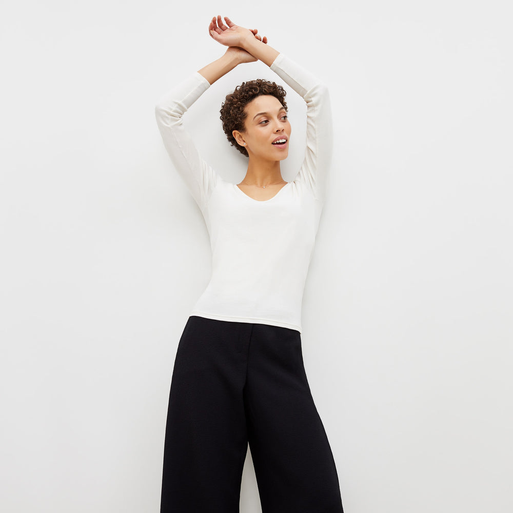Front image of a woman standing wearing the marcia top in fine ribbed cotton in ivory