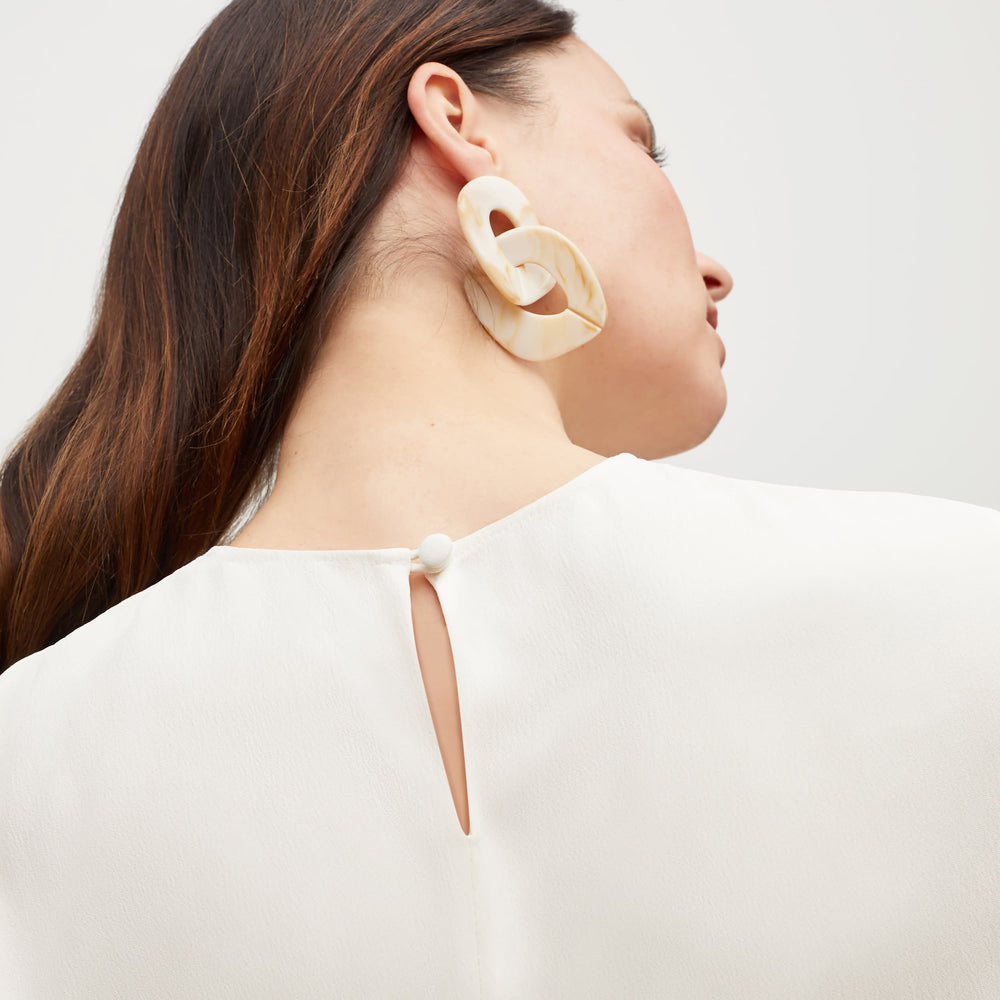 Front image of a woman standing wearing the Carrie Top—Soft Wave in Alabaster
