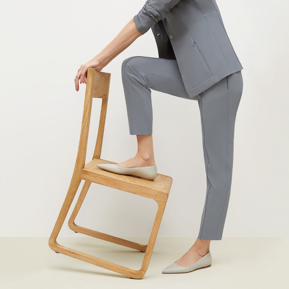 Side image of a woman standing wearing the Rowan Flat—Embossed Croc in Gray