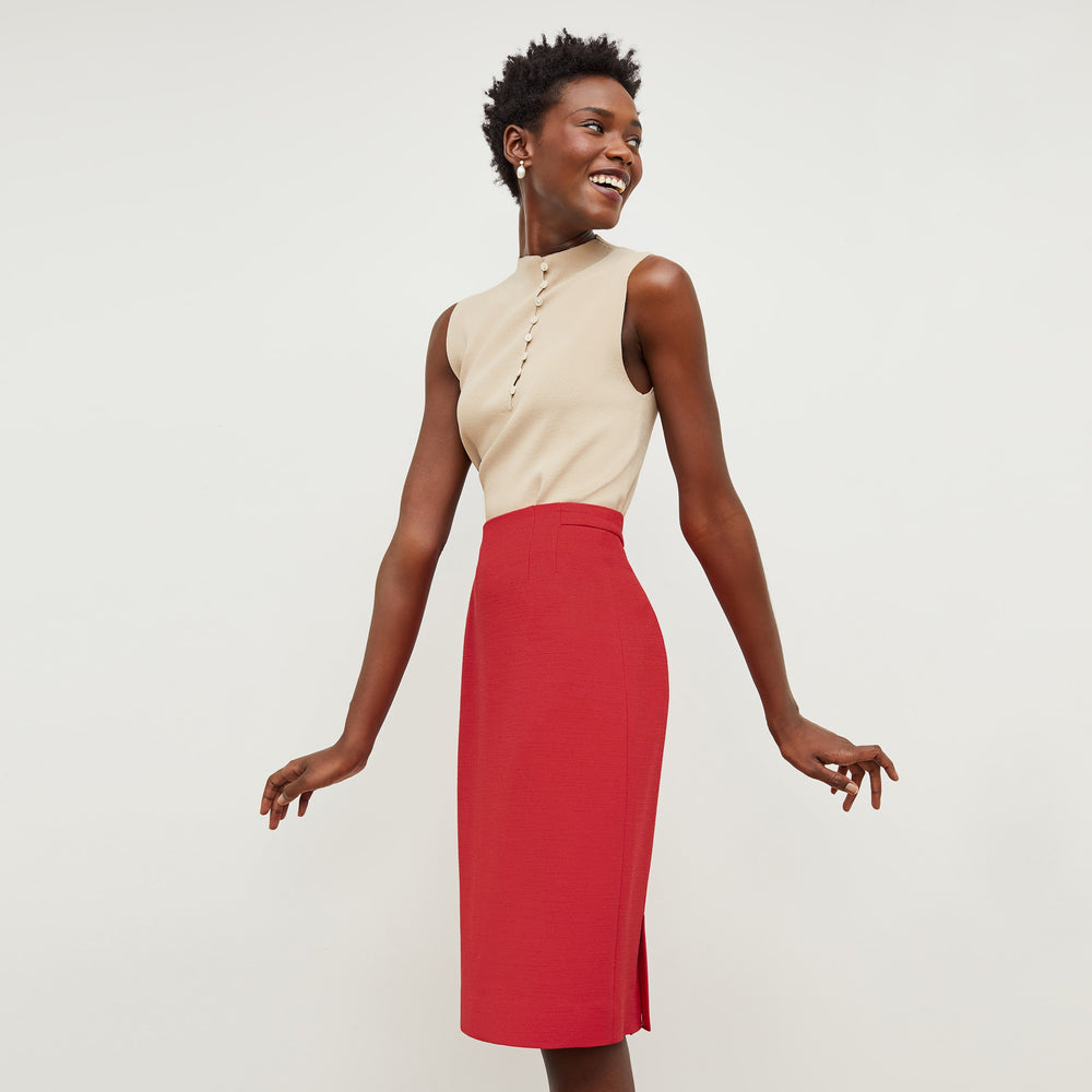 Side image of a woman standing wearing the Malki top in latte