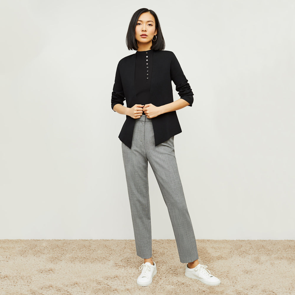 Front image of a woman standing wearing the malki top in black