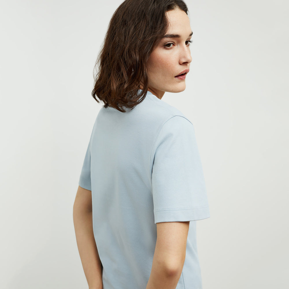 Back image of a woman standing wearing the Leslie T-Shirt—Compact Cotton in Sky Blue