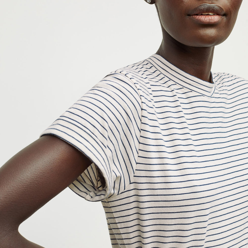 Detail image of a woman standing wearing the Leslie T-Shirt—Thin Striped Cotton in Ivory / Coastline