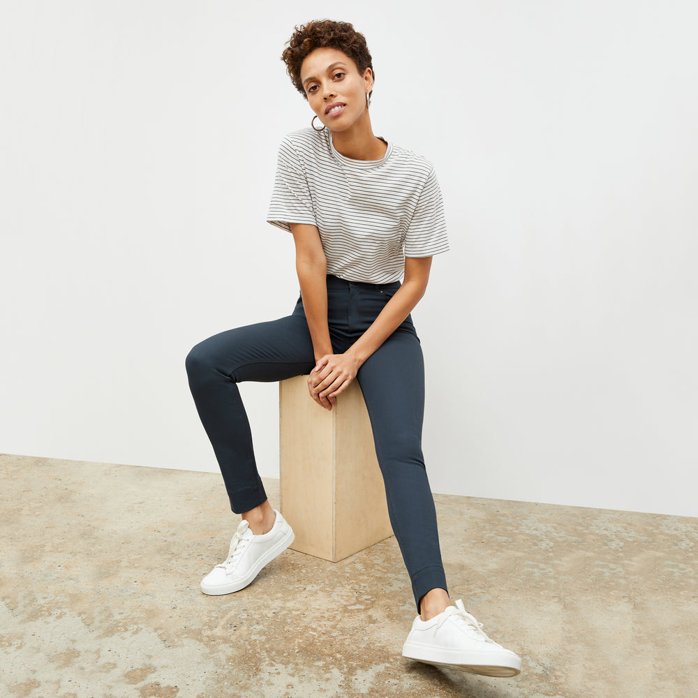 Front image of a woman standing wearing the Leslie T-Shirt—Thin Striped Cotton in Ivory / Coastline