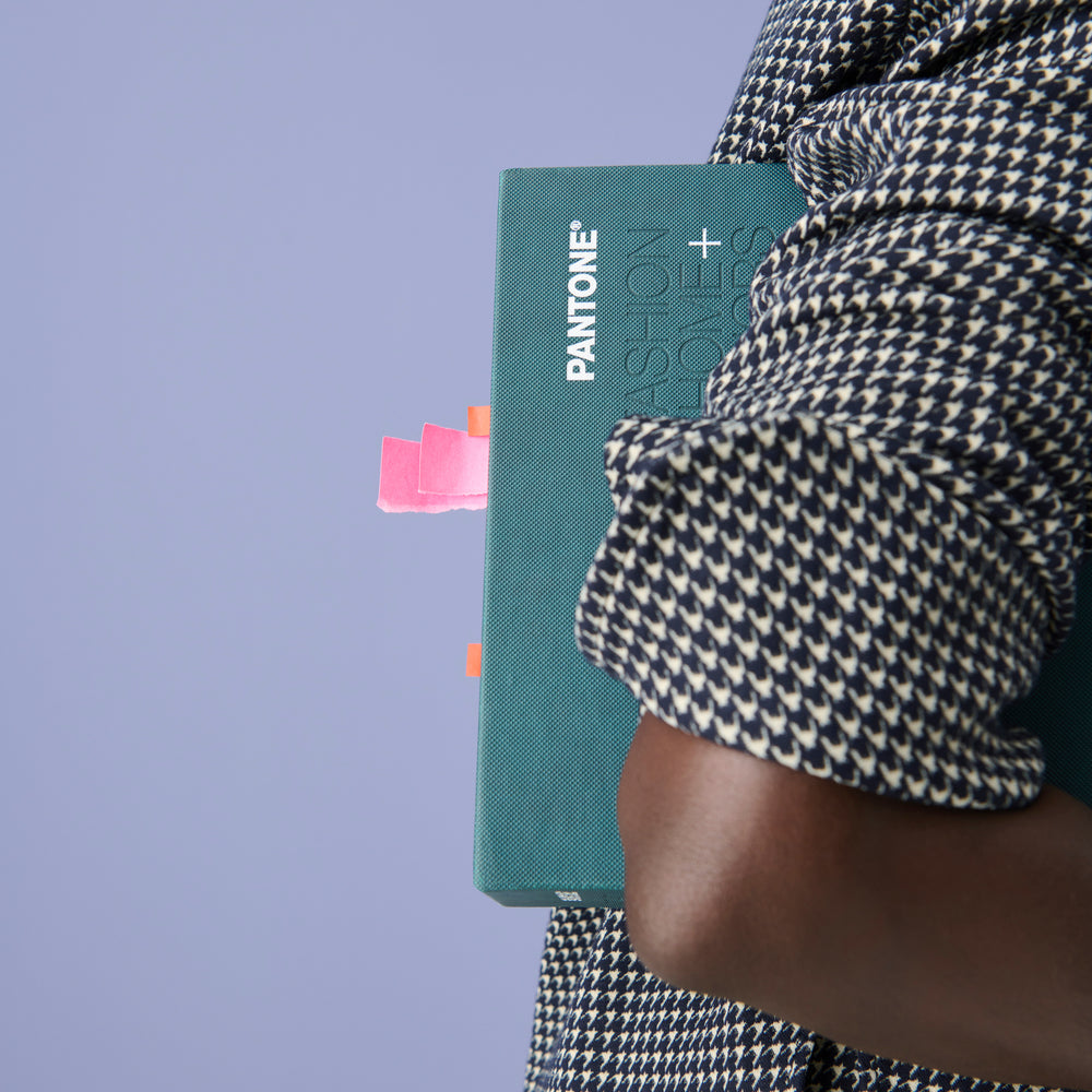 Image of a woman in the Tully Top in Houndstooth holding a pantone book under her arm