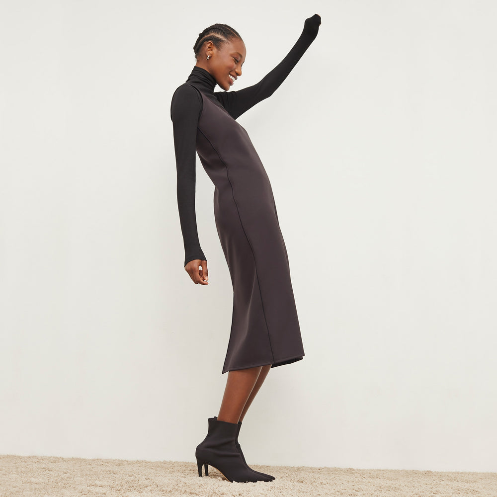 Side image of a woman standing wearing the Elsa Dress—Light Scuba in Haze