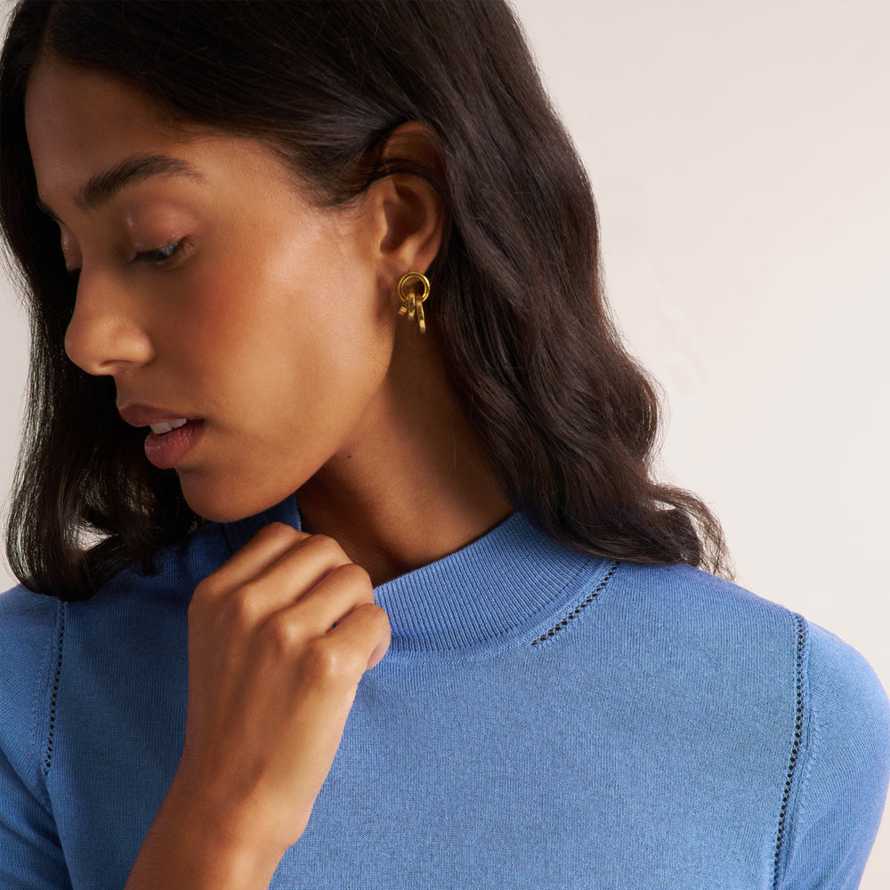 Woman wearing a blue splendor color short sleeve sweater with beige wide leg pants