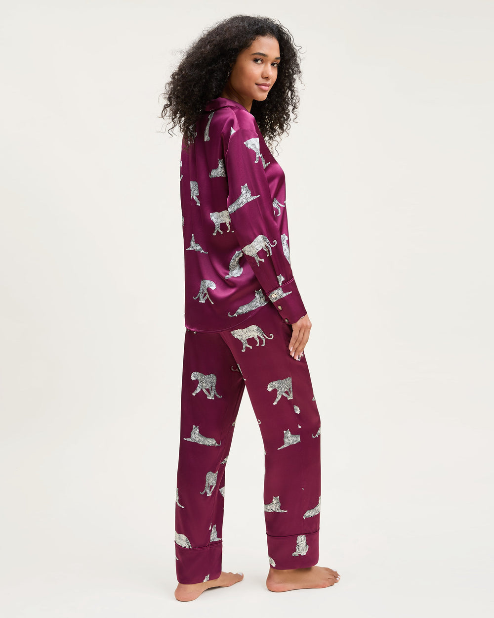Person wearing a purple pajama set with animal patterns on a white background