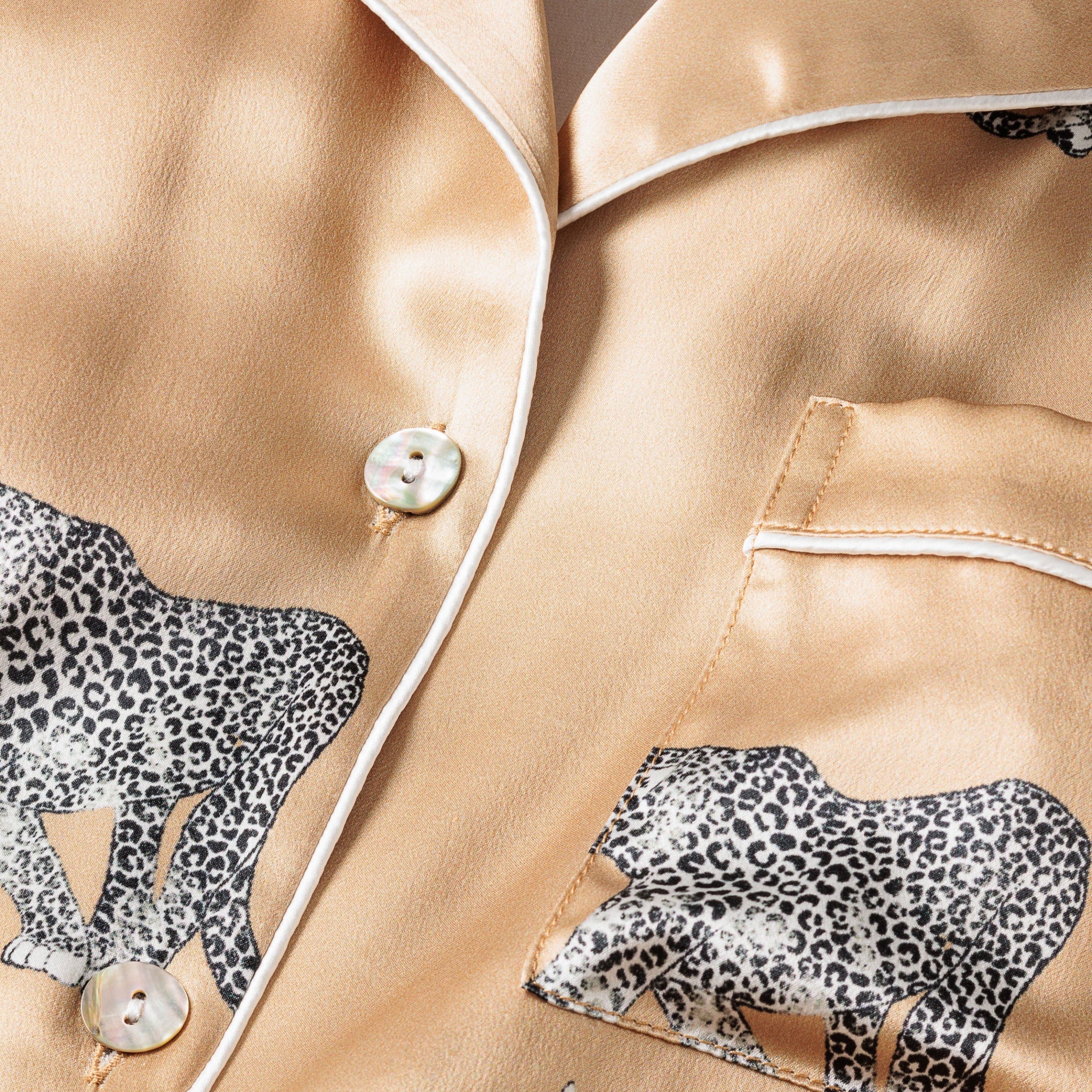 Close-up of beige satin pajama set with leopard print details