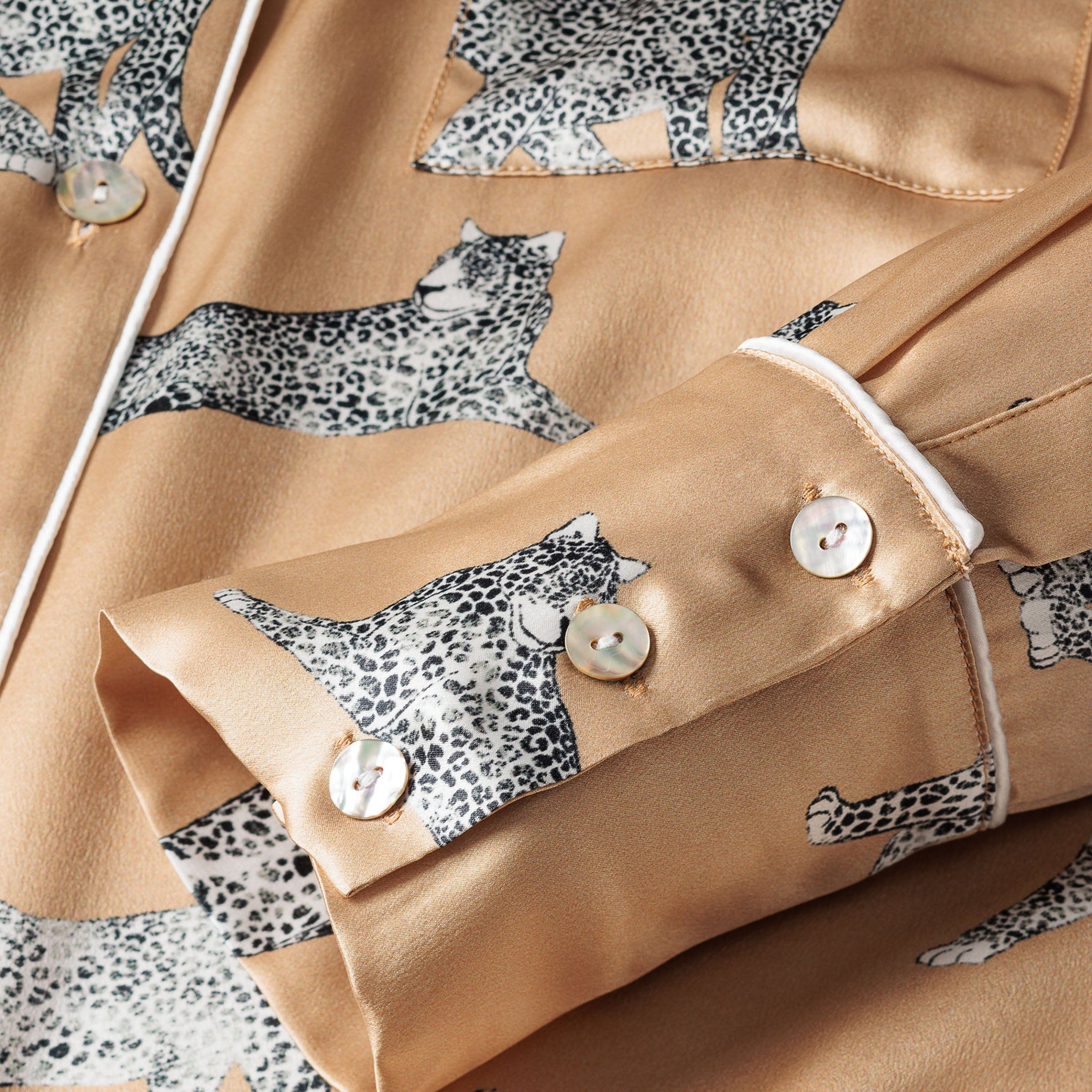 Close-up of a beige fabric with leopard print patterns and buttons.