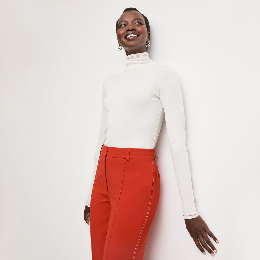 front image of a woman wearing the axam top in white