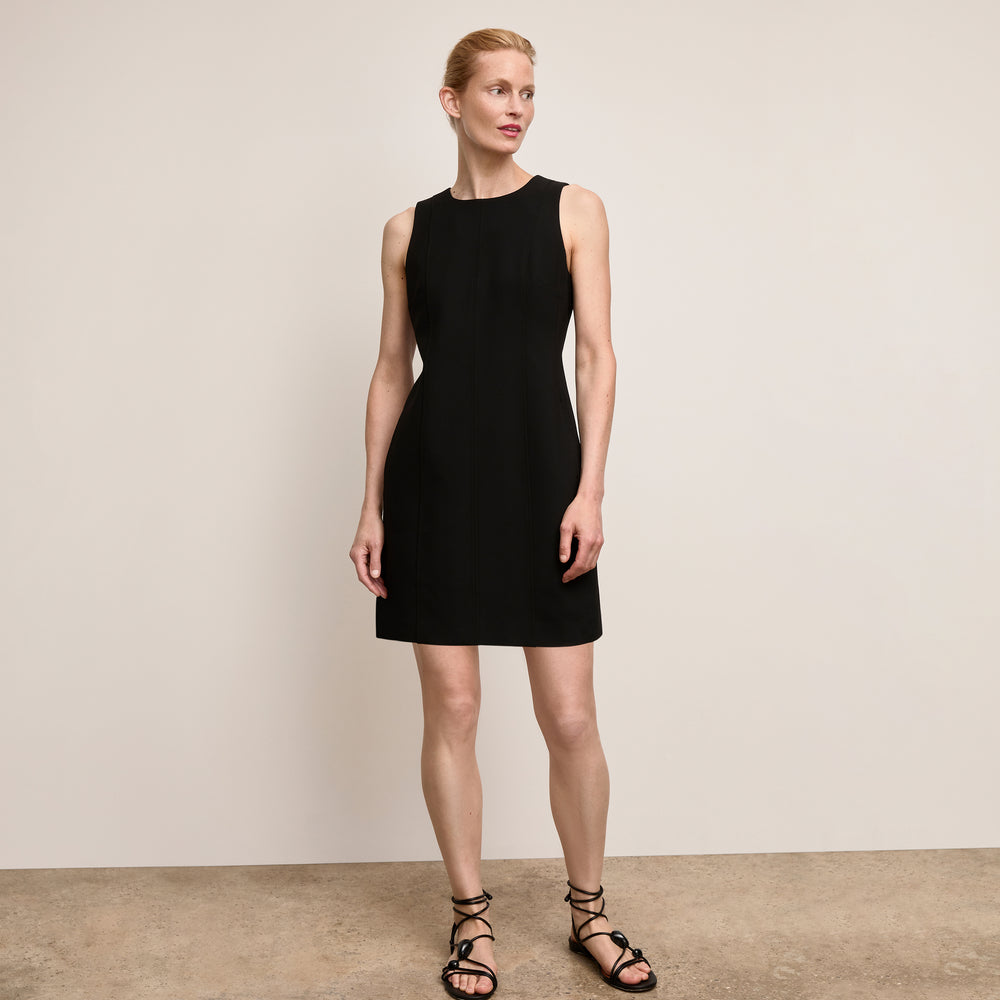 Woman wearing a black dress against a plain background