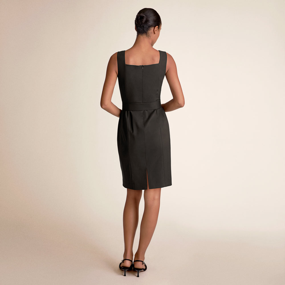 Woman wearing a black dress on a beige background