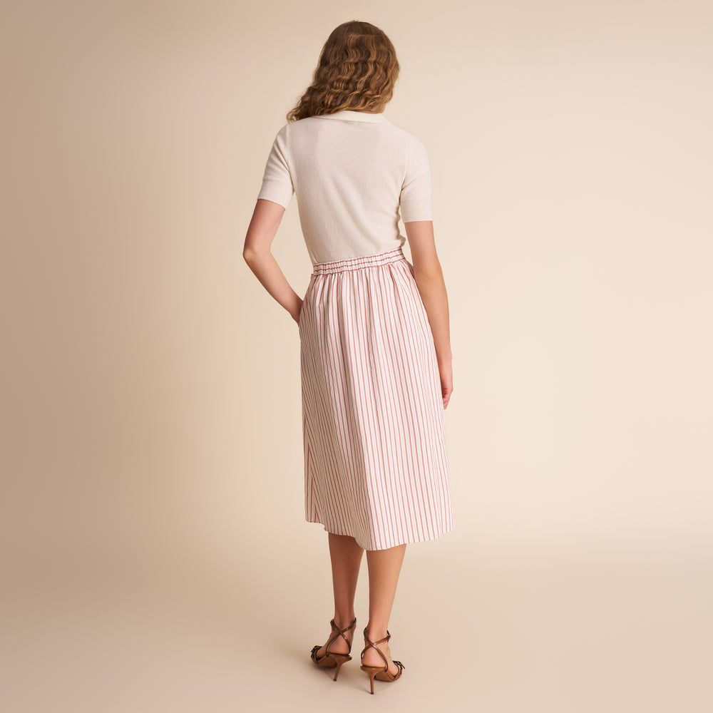 back of woman in orange and white stripped skirt