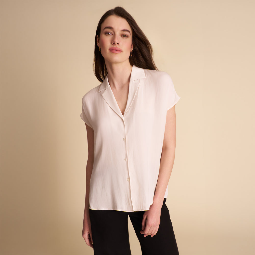 woman in white blouse on beige background.