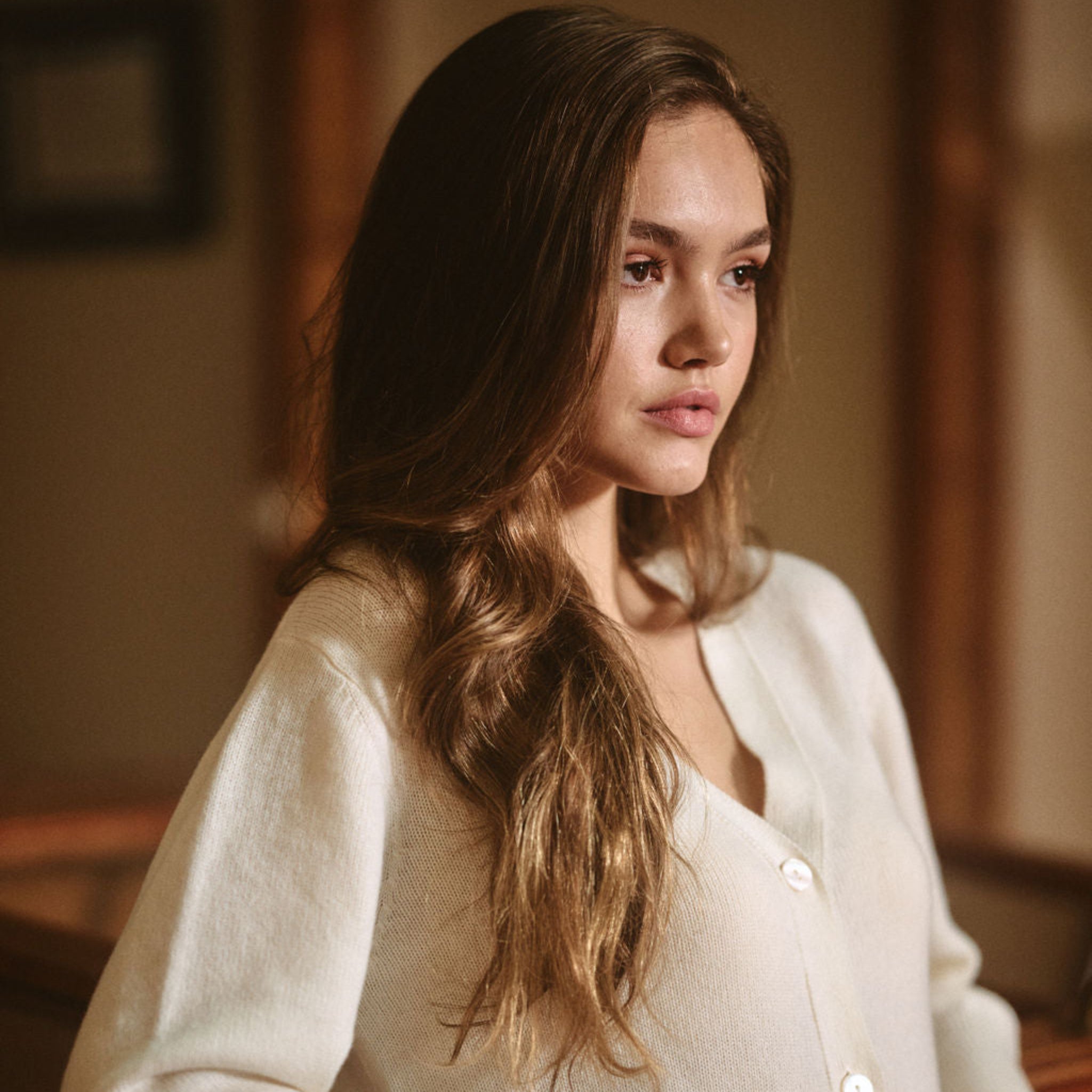 Woman wearing a white sweater in an indoor setting