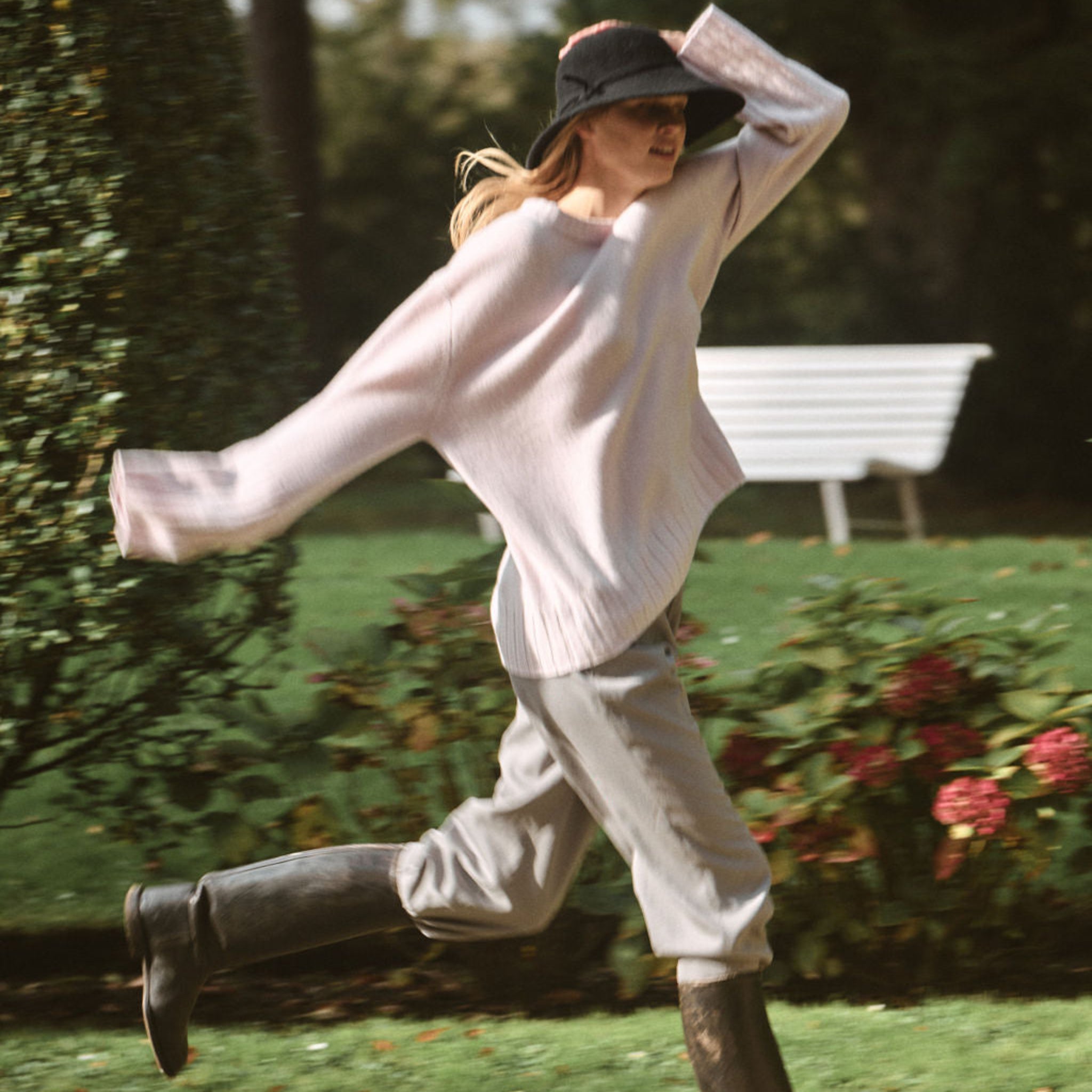 Person running in a park with a white shirt and dark hat