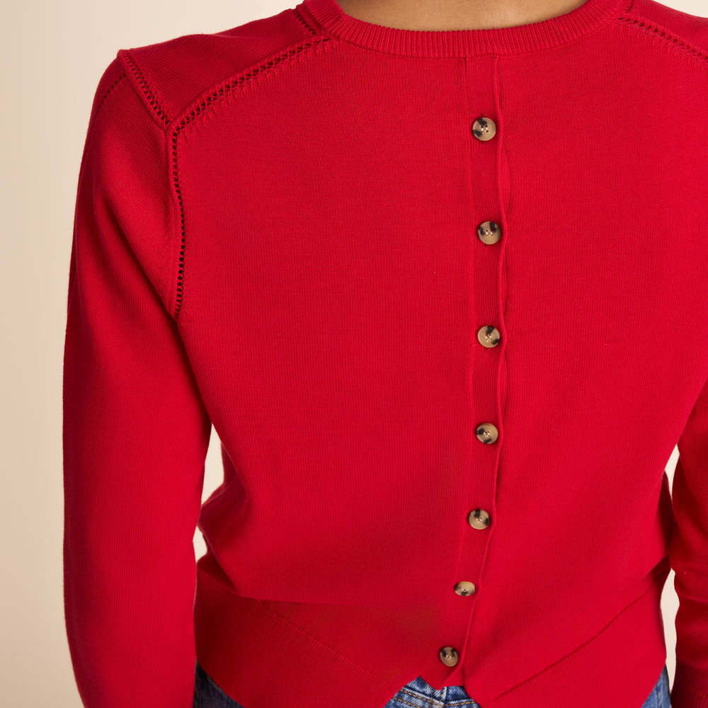 Red button-up sweater on a beige background