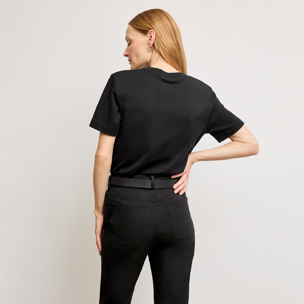 back image of a woman standing wearing the leslie top in compact cotton in black