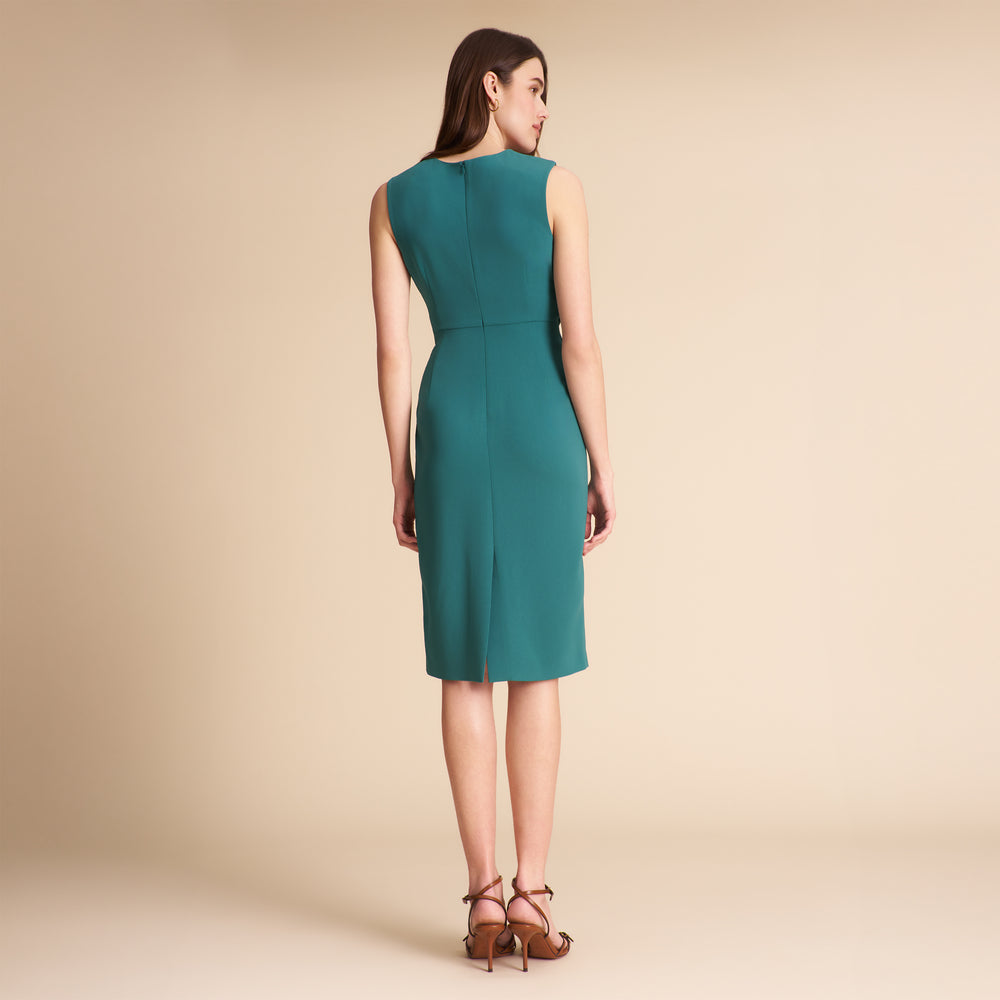 Woman wearing a teal dress on a beige background